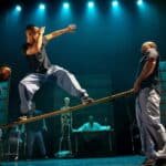 Danseur en équilibre sur un banc porté dans le spectacle Déséquilibré